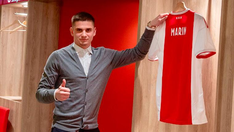 Razvan Marin poses beside his new T-shirt in the changing room of the Ajax