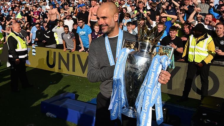 Guardiola Poses with the trophy of champion of Premier