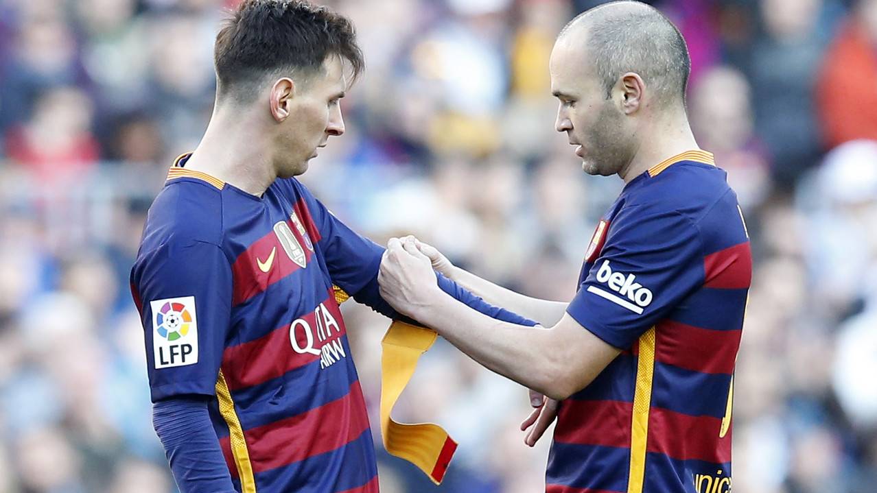 Iniesta, poniéndole el brazalete de capitán a Leo Messi