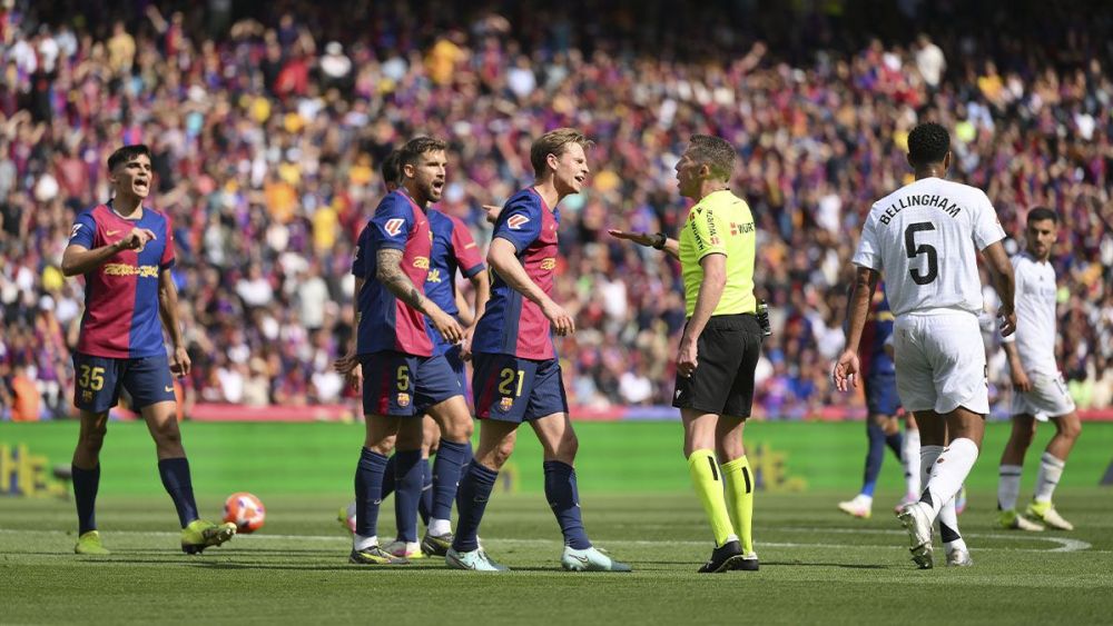 Jugadores del Barça conversan con el árbitro Hernández Hernández durante el Clásico (4-3)