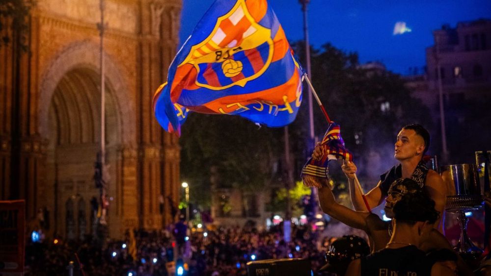 Marc Casadó enarbolando la bandera del FC Barcelona luego de que el autocar culé llegara al Arc de Triomf