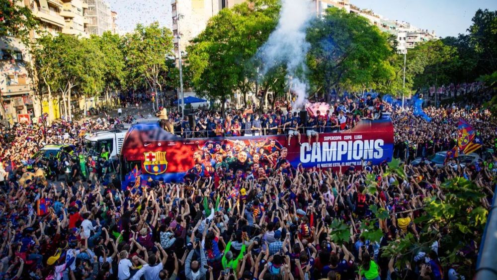 Jugadores del FC Barcelona en la rúa con la afición rodeando el autocar