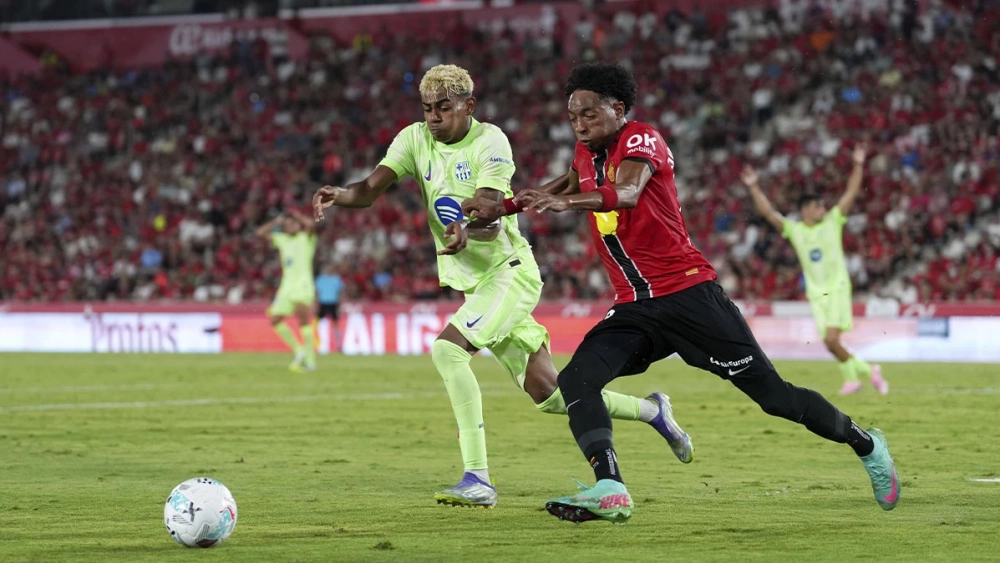 Lamine Yamal disputes a ball with Johan Mojica during the Mallorca-Barça (0-3)